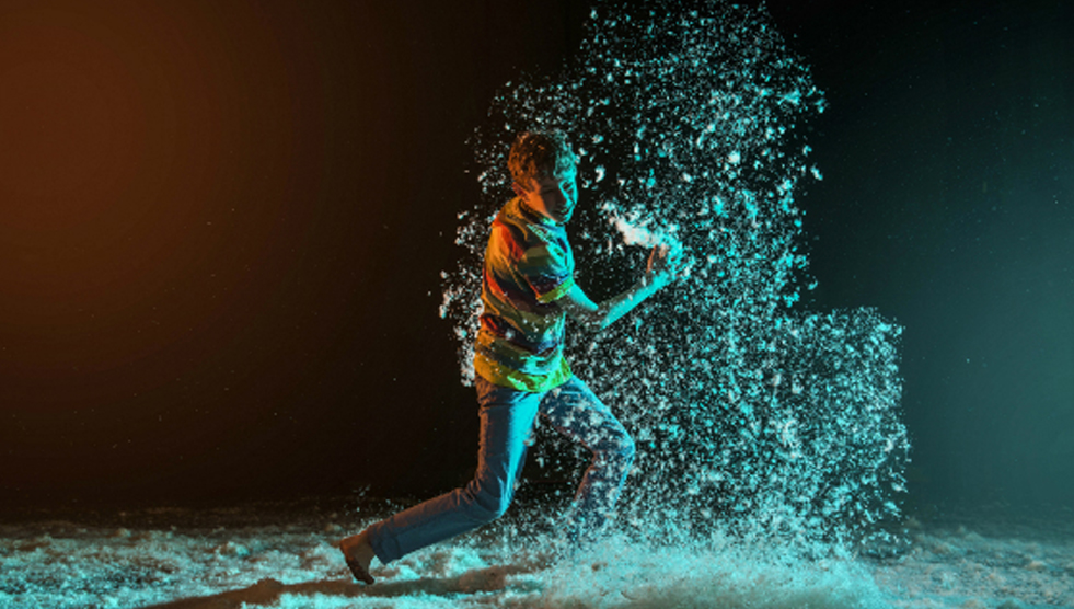 Ticket Giveaway: A young man is moving and throwing feathers in the air