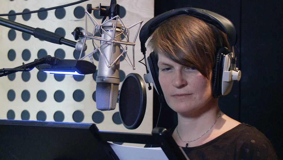 Screenability: A young person with headphones is sitting in a recording studio