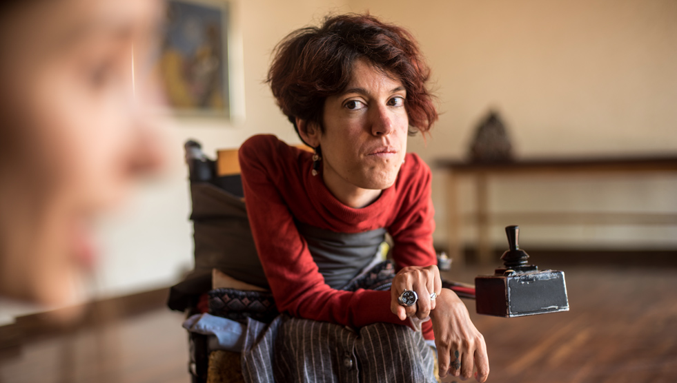 Collection: A woman is sitting in a wheelchair and is looking at the camera