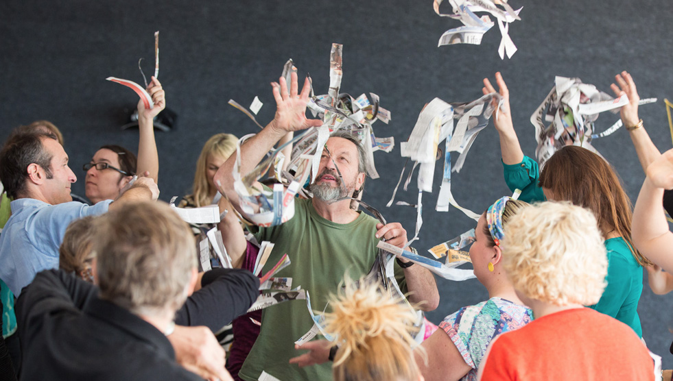 Engaging Students with Disability Forum: People are standing in a group and throwing paper strips in the air